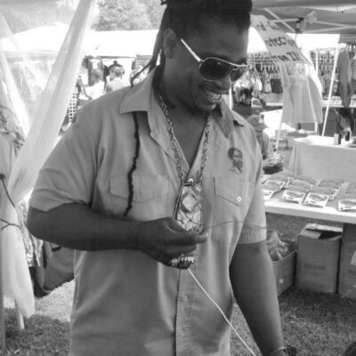 Ras Tree making jewelry at booth.