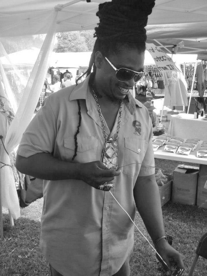 Ras Tree making jewelry at booth.